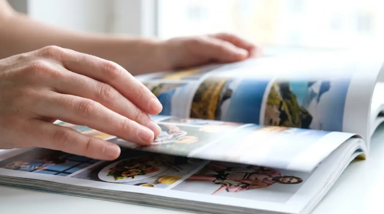 Close view of fingers flipping through the pages of a magazine